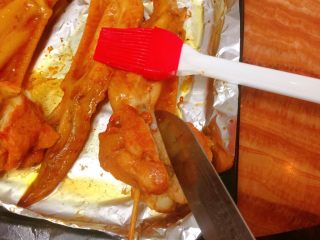 新奥尔良烤鸡翅,10分钟后，再拿出把翅根较厚的地方用刀子切开，以便容易熟，均匀。再次翻面刷油。