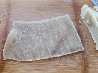 猪皮冻,煮好的猪皮捞出用温水冲去浮沫，然后用刀将肉皮里层的白色油脂刮掉