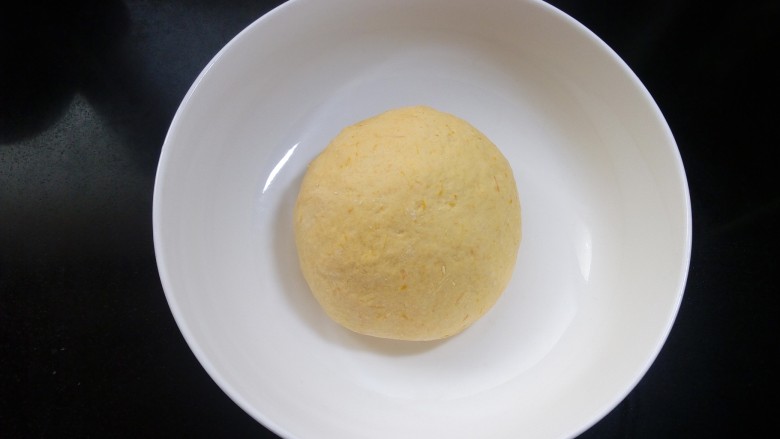 仿真玉米包,用筷子搅拌成絮状，然后揉成光滑的面团。盖上保鲜膜发酵。
