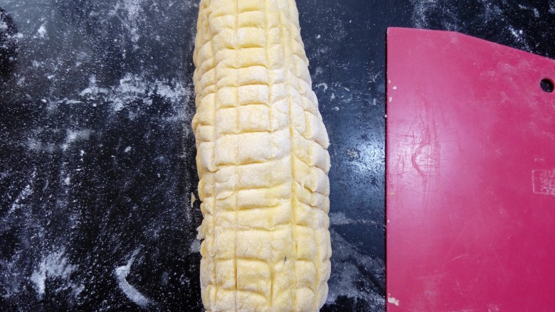 仿真玉米包,整理成一头细，一头粗的玉米形状。用刮板或刀压出纵横交错的印痕。