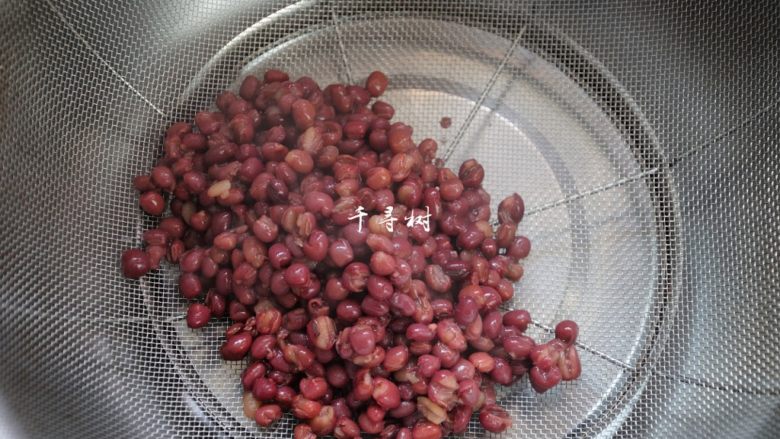 红豆沙洗沙馅 纯正细腻香甜豆沙馅做法,取一个细网筛置于干净的容器上，把煮好的红豆舀进去一勺。