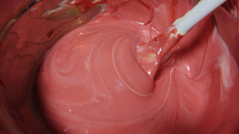 红丝绒波点蛋糕卷,剩下的面糊加入红丝绒溶液，翻拌均匀。