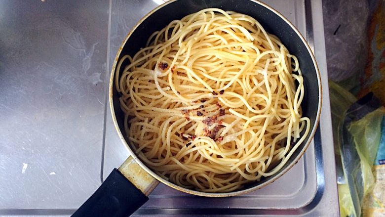 扁豆焖意面,待锅内的汤汁剩下三分之一时，将意大利面倒在扁豆上，将用油泼过的干辣椒碎淋在面条上，并均匀洒入适量的盐在面条上。