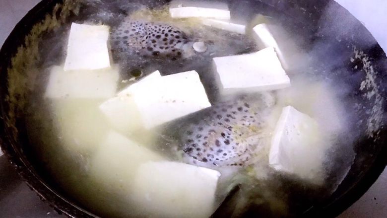 三文鱼头炖豆腐,煮至三文鱼头变色放入豆腐一起煮