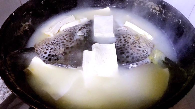 三文鱼头炖豆腐,煮至汤汁变白色即可盛出