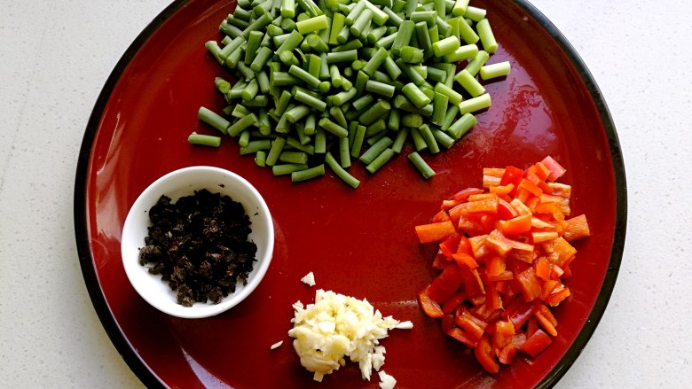 豆豉炒肉丁,把蒜苔切成小段，新鲜红椒，豆豉和大蒜切碎备用。