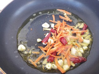 砂锅鱼,另起一锅，把胡萝卜丝和葱姜蒜还有干辣椒都放锅里