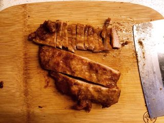 自制蜜汁叉烧,切片。注意，要切断猪肉的纹理。把切好的肉片排在盘中。