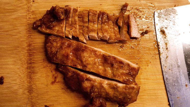 自制蜜汁叉烧,切片。注意，要切断猪肉的纹理。把切好的肉片排在盘中。