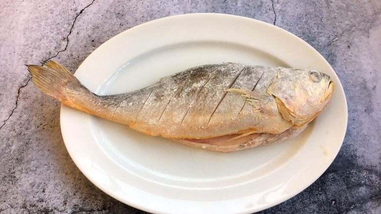 做年货 年年有余 干烧大黄鱼,将鱼的两面都蘸上面粉。