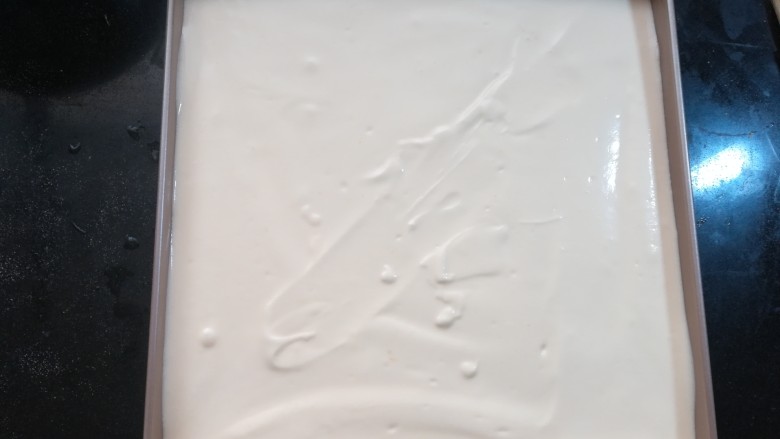 小清新柠香奶油卷（烫面法,烤盘里可以垫上油纸或油布。如果是不粘烤盘，也可以不垫东西，也能出毛巾面。用刮刀抹平，端起烤盘，在台面上轻震几次进出内部的气泡。
