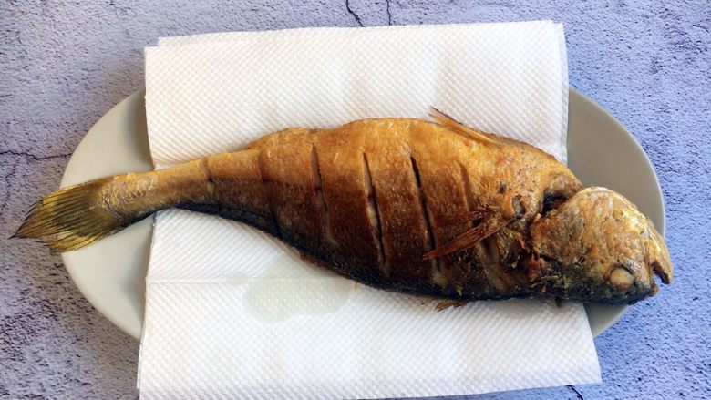 做年货 年年有余 干烧大黄鱼,把煎好的鱼用厨房用纸吸一下油。