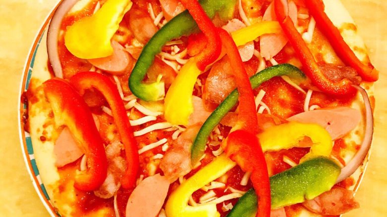 DIY亲子披萨,制作6寸披萨时，也是按照上述顺序摆放适量腊肠片和火腿肠片。