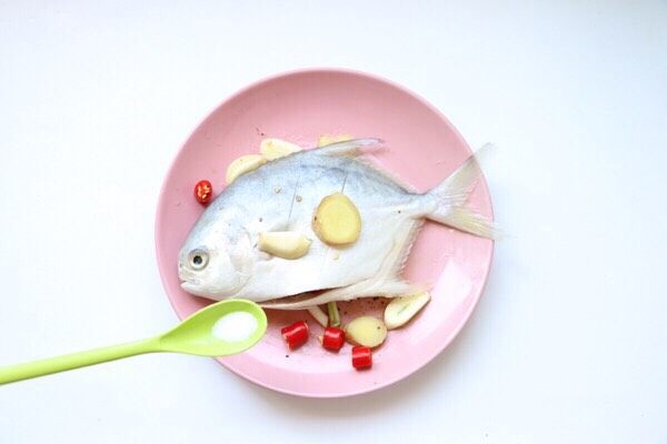 清蒸鲳鱼,先腌制鲳鱼：鲳鱼两面划两刀方便更易入味，放姜蒜红尖椒、盐1g、撒少许黑胡椒