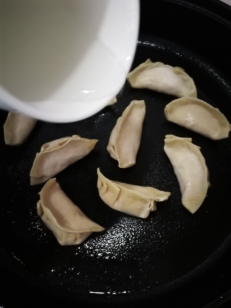 韭黄虾仁煎饺,等饺子煎到底部有点微微发黄时加入半碗热水。