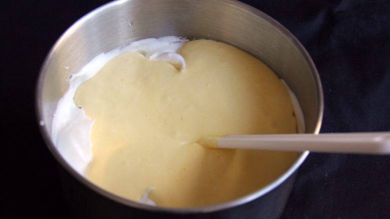 奶酪戚风蛋糕,将蛋糕糊倒入蛋白中继续翻拌均匀，操作同上。