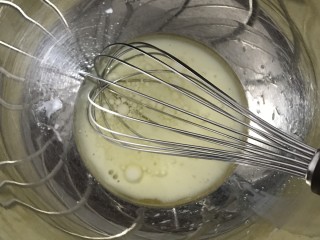 爱心草莓蛋糕卷,将玉米油和水倒入大碗中，用手动打蛋器搅拌均匀。
