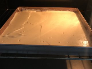 爱心草莓蛋糕卷,放入预热好150度烤箱中，烤20分钟。出炉后从高处摔一下，垫张油纸倒扣在烤网上，撕掉油布，再翻转过来盖上油纸晾凉。