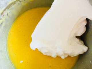 新春“福”到蛋糕,取三分之一蛋白，加入蛋黄溶液中。翻拌均匀。