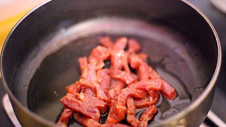 黑椒牛肉炒意粉,锅中下色拉油，倒入牛肉炒至变色。