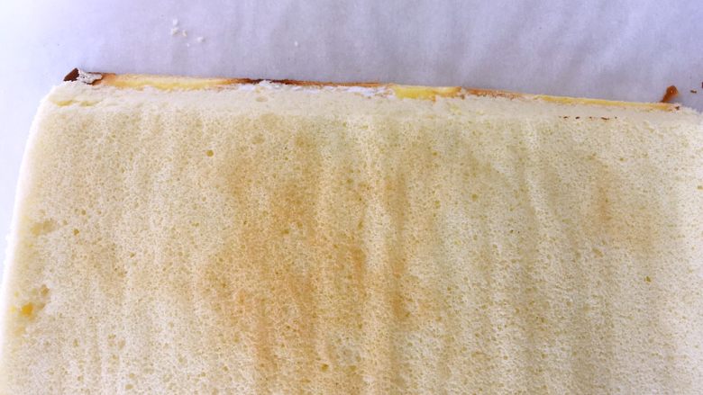 虎皮蛋糕卷,将蛋糕卷铺在虎皮蛋糕卷上，用刀呈45度角裁掉一侧的边角，这样卷到尾部的时候蛋糕不会太厚，会很平整的贴在卷起的蛋糕卷上