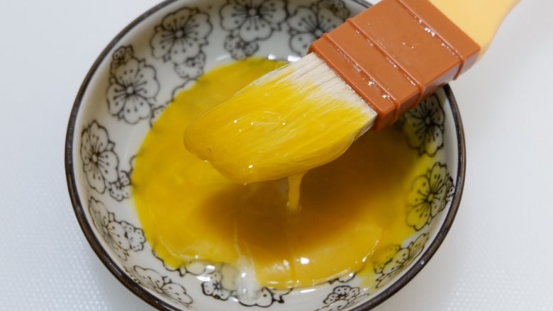 莲蓉蛋黄酥（不用醒面，不用揉出膜）,收口向下放入烤盘。一个蛋黄兑1勺清水，调成蛋黄水