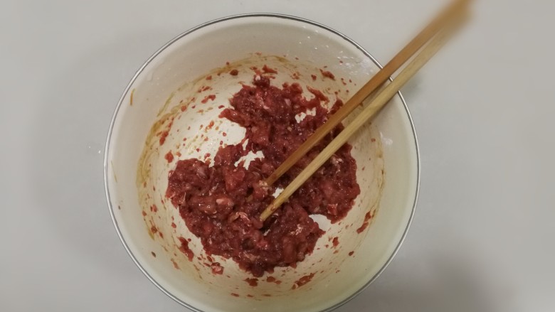 白玉翡翠包子(香菇牛肉包),用筷子顺时针搅拌均匀，期间少量多次加入葱姜水打入肉馅里