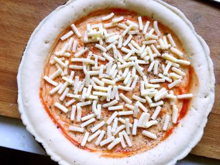 鲍旺财披萨🍕,刷披萨酱，洒黑胡椒，放入一层马苏里拉芝士