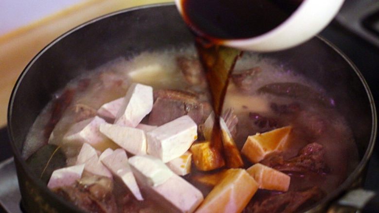 荔浦芋头烧鸭,倒入步骤四准备好的调味品，盖上锅盖继续熬煮。