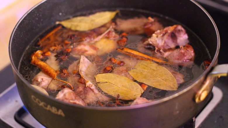 荔浦芋头烧鸭,倒入五碗水，下生姜与香料，盖锅盖中火熬煮。
