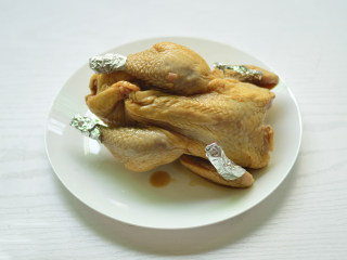 柠香烤全鸡,隔天将腌好的鸡取出，将容易烤糊的鸡尖和鸡腿末裹上锡纸