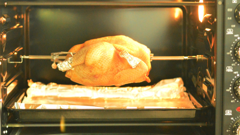 柠香烤全鸡,将烤盘上垫上锡纸，放在最下层，将固定好的鸡放入烤箱，230度，烤50分钟