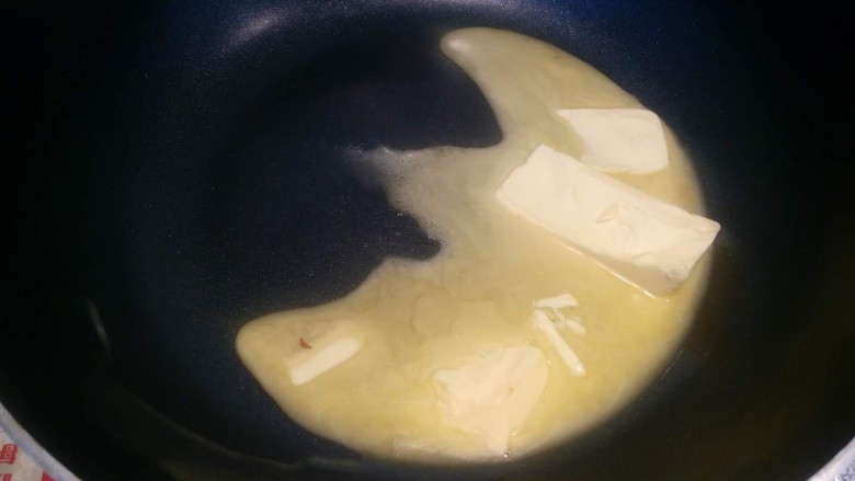 年味~缤纷果干牛轧糖,熬糖一定要用不沾锅哦，最好用硬一点的硅胶铲方便操作。锅里放入称量好的黄油。