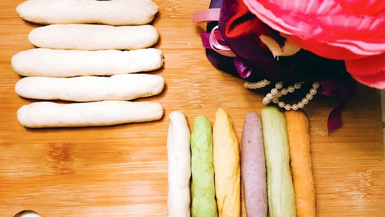 多彩迷你饺子,分别在面团上取下一块，各自搓成彩色面棍和纯色面棍。