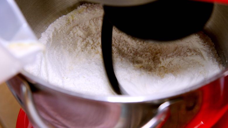 金钱小面包,发酵液慢慢倒入厨师机内搅拌。