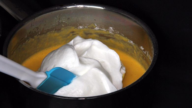 南瓜泥戚风蛋糕,取三分之一的蛋白霜加入到蛋黄糊中翻拌。