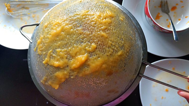 木瓜椰蓉奶冻,搅动过程中，注意筛子的背面，当面糊下不去时，可以用打蛋器刮一刮筛子的底部。