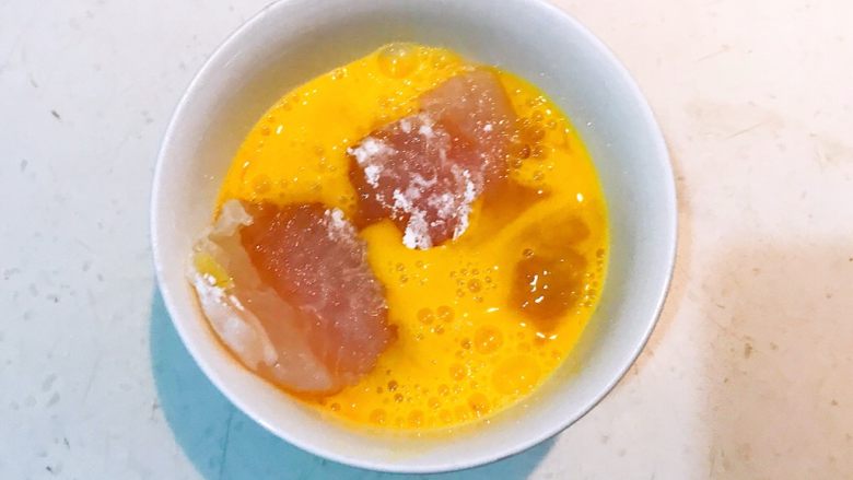 香煎黑椒龙利鱼,把腌制好的龙利鱼段放入鸡蛋液中，均匀的裹上一层蛋液