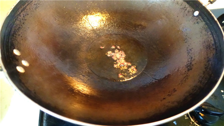 干煸花菜炒腊肉,锅内再添加少许油，下入花椒，小火炒制花椒变得微焦，将花椒捞出不用。