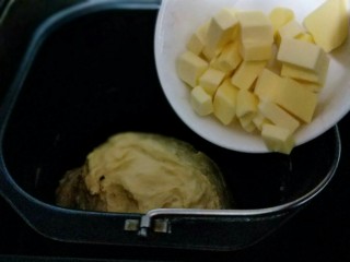 南瓜豆沙花纹水立方吐司面包,20分钟后面团再扩展阶段，这时加入室温软化的黄油。(室温自然软化即可。)