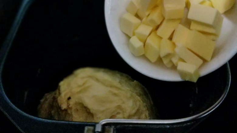 南瓜豆沙花纹水立方吐司面包,20分钟后面团再扩展阶段，这时加入室温软化的黄油。(室温自然软化即可。)