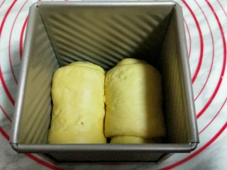 南瓜豆沙花纹水立方吐司面包,再卷起来，两个做完，卷起时注意手法，保持手法一直，做出来的吐司才漂亮。