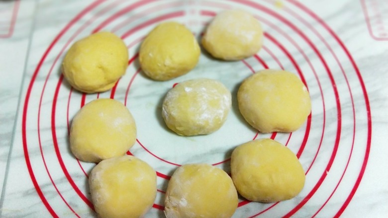 香甜松软的南瓜小面包,发酵好的面团，可以用手指捅一下，不回缩即为发酵完成。将面团取出排气，分成9等份揉圆。