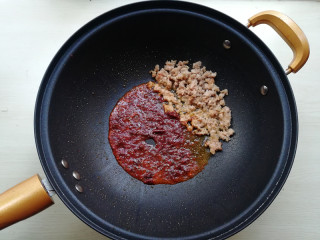 【肉末炒蒜苔】,将肉末拨至一边，下入郫县豆瓣酱炒出红油