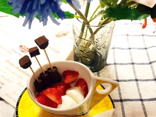 巧克力浓情草莓甜心酸奶杯,用牙签将切块的巧克力块插入完整的巧克力上，完成造型。