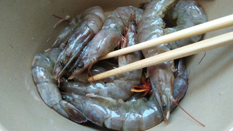 香辣可口的蒜蓉烤虾，营养下饭神器,用筷子搅拌均匀，进行腌制，腌制10-15分钟。