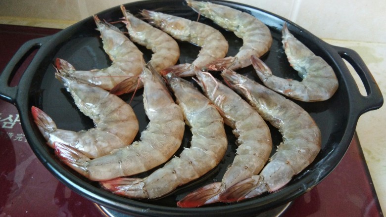 香辣可口的蒜蓉烤虾，营养下饭神器,油热把腌制好的虾放在烤盘上，烤3-5分钟。