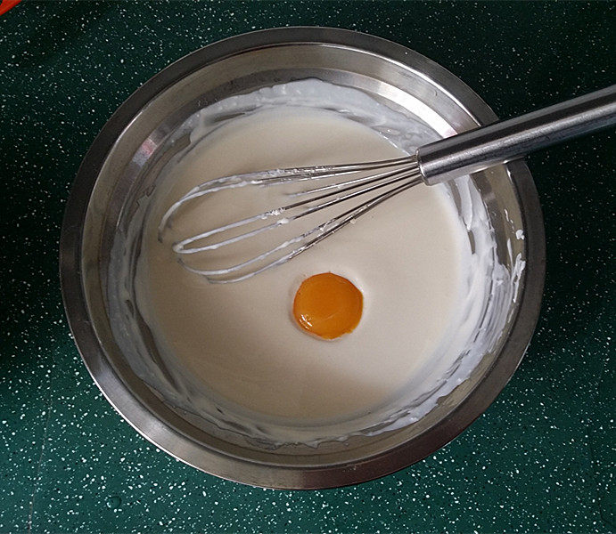 轻乳酪芝士蛋糕,离火将蛋黄逐个加入快速拌匀、否则蛋黄容易变成蛋花了