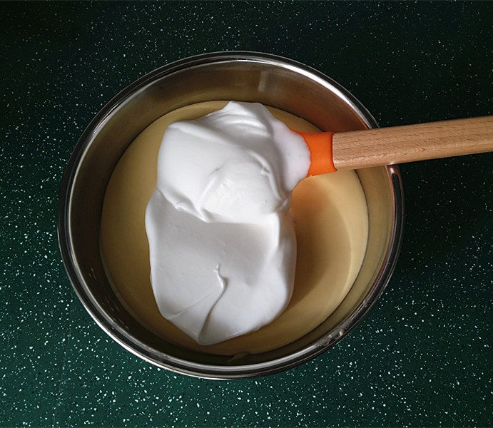 轻乳酪芝士蛋糕,取1/3蛋白糊至蛋黄盆中、同样用翻拌手法将蛋白糊与蛋黄糊拌匀