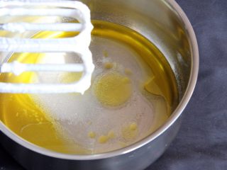 咖啡戚风蛋糕,蛋盆中加入油和清水，再加入盐和15克细砂糖，打蛋头也不用洗了，继续搅打均匀。